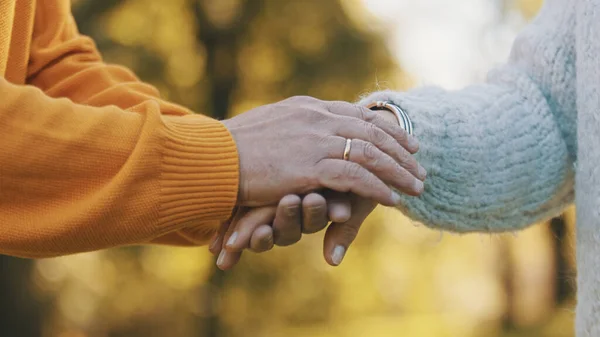 Doe je gerimpelde handen dicht. Gelukkig oud stel knuffelend in het park. Senior man flirt met oudere vrouw. Romantiek op hoge leeftijd dansen op herfstdag — Stockfoto