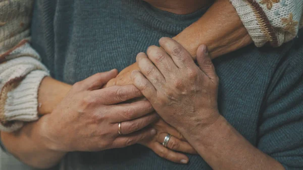 Kırışık elleri kapayın. Parkta kucaklaşan mutlu yaşlı çift. Kıdemli adam yaşlı bir kadınla flört ediyor. Yaşlılıkta aşk Sonbahar günü dans eder — Stok fotoğraf