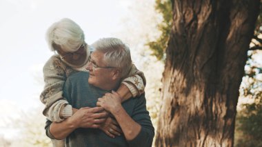 Parkta keyifli bir gün. Kıdemli adam yaşlı bir kadınla flört ediyor. Sonbahar günü dans et.