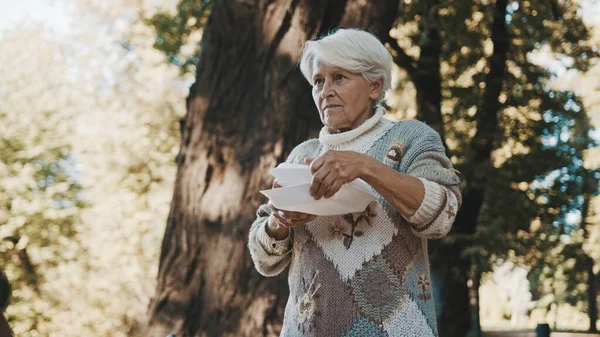 Old vulnerable homeless woman getting free charity meal