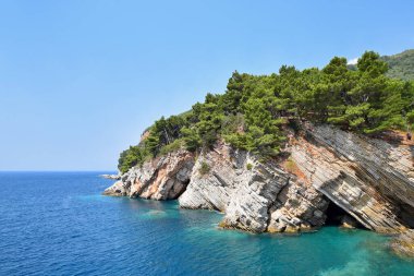 Karadağ 'ın Petrovac kenti yakınlarındaki resimli kayalıklar, yeşil çam ağaçları ve gök mavisi deniz