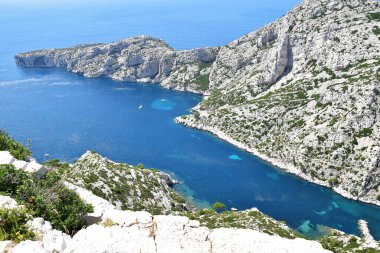 Beyaz dağlarla çevrili gök mavisi sularla dolu pitoresk bir koy. Fransa, Marsilya yakınlarındaki Calanques Parkı