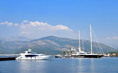 Porto Karadağ 'da güzel yatlar ve açık bir yaz gününde arka planda dağlar