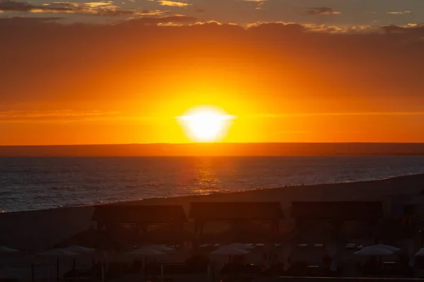 Puesta de sol sobre la playa con gazebos — Foto de Stock