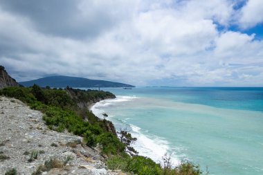 Bulutlu gökyüzüne karşı mavi deniz