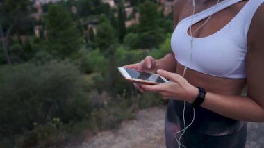 Sosyal medyayı kullanmak ve yazmak için akıllı telefonunu kullanan genç bir sporcunun ellerini seçici bir şekilde odakla. Teknoloji konsepti, bağlantılı. Odaklanmamış arkaplan