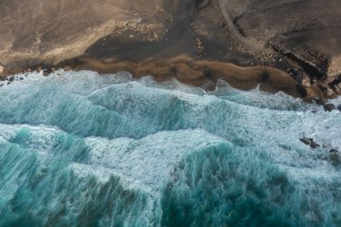 La Solapa Beach, Fuerteventura 'daki dramatik kıyı şeridi, dalgalar ve volkanik kayalıkların manzarası..