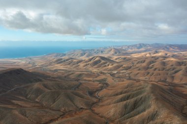 Sicasumber Dağı 'nın dramatik yamaçlarına giden eğimli asfalt bir yolun havadan perspektifi.