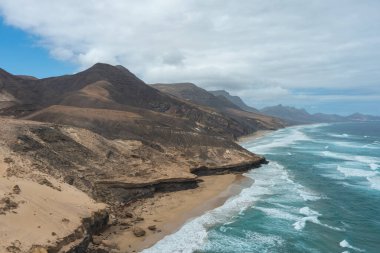 Fuerteventura 'daki Sicasumbre sıradağlarının panoramik görüntüleri. Volkanik arazi, kayalık çıkıntılar ve sonsuz ufuklar Kanarya Adaları 'nın eşsiz coğrafyasını gözler önüne seriyor.
