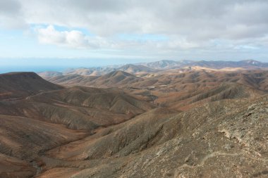 Fuerteventura 'daki Sicasumbre sıradağlarının panoramik görüntüleri. Volkanik arazi, kayalık çıkıntılar ve sonsuz ufuklar Kanarya Adaları 'nın eşsiz coğrafyasını gözler önüne seriyor.