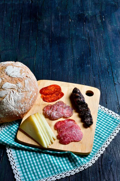 Yanında da kırmızı şarap ve peynir tabağı var.