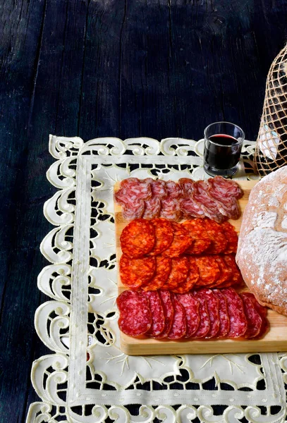 Yanında da kırmızı şarap ve peynir tabağı var.