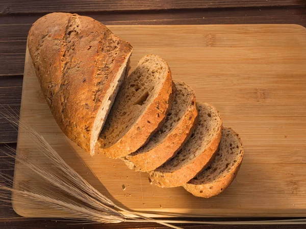 Gray bread with grains on a wooden board and ears morning — Stock Photo, Image