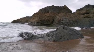 Dalgalar Vizcaya 'daki Bakio sahilindeki kayalara vuruyor.