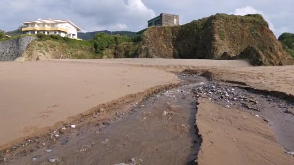 ビーチに形成された小さなストリームを介して海に行く水 — ストック動画