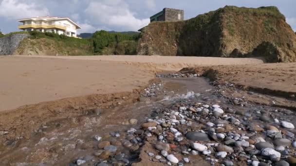 水流通过海滩上形成的一条小河流入大海 — 图库视频影像