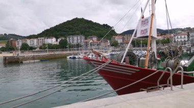 Bulutlu bir yaz gününde balıkçı tekneleri Lekeitio limanına demirledi.