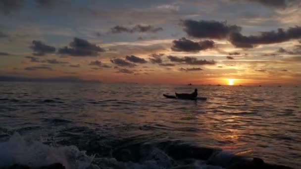 Chłopiec Odpoczywa Ogląda Zachód Słońca Wiosle Surfując Mijając Sylwetkę Łodzi — Wideo stockowe