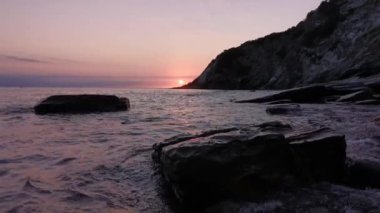 Yaz günü Cantabrian Denizi 'nin bakir bir koyunda günbatımı