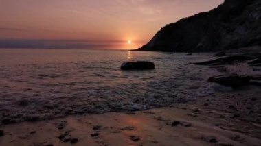 Yaz günü Cantabrian Denizi 'nin bakir bir koyunda günbatımı