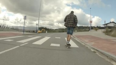 Ekose ceketli genç adam kısa kot pantolon ve uzun çorapları yırttı.