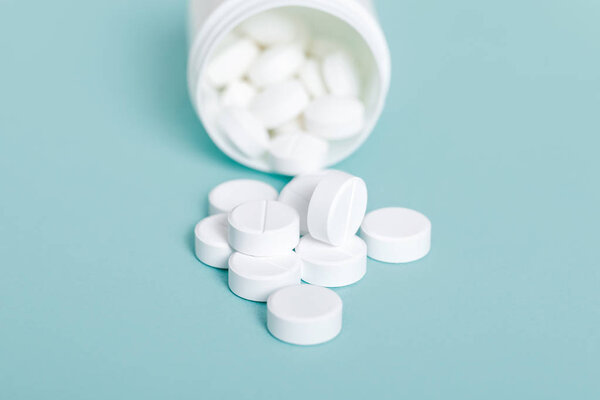 Таблетки, разливающиеся из бутылки с таблетками