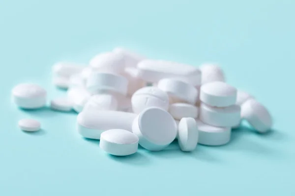 Weiße Pillen auf blauem Hintergrund — Stockfoto