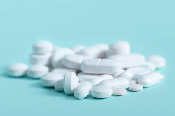 White pills on blue background — Stock Photo, Image