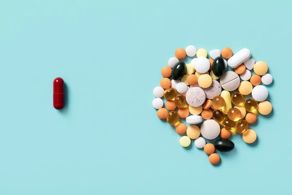 一粒红丸和不同颜色的药丸 — 图库照片