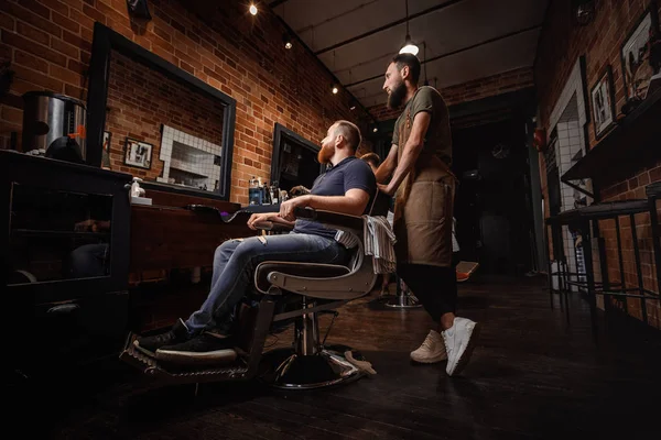 Barber and bearded man in barber shop — Stock Photo, Image