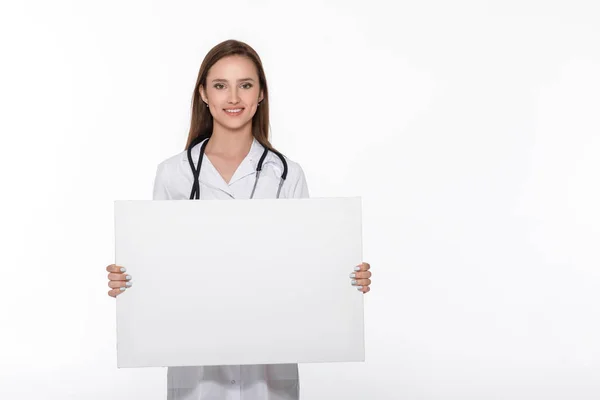 Médico de uniforme branco segurando placa em branco — Fotografia de Stock