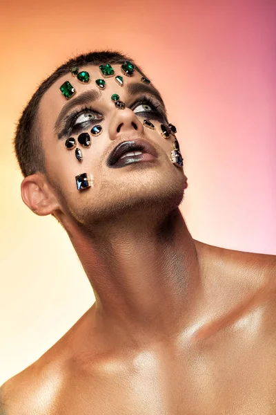 fantasy art makeup. man with rhinestones and jewels