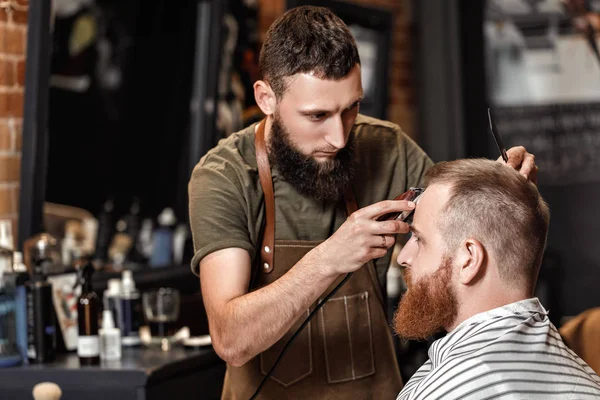 Barber and bearded man in barber shop