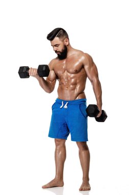 kaslı adam dumbbells ile yapıyor.