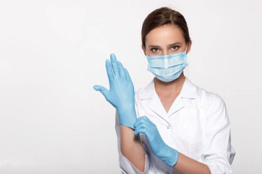 Doktor maske ve eldiven giyiyor.
