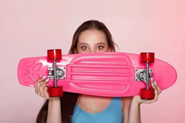 Красивая женщина держит скейтборд — стоковое фото