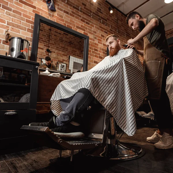Frisör och skäggig man i frisersalong — Stockfoto