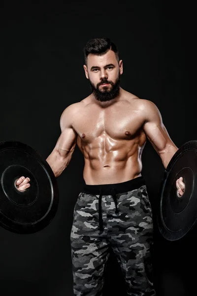 Muskulöser Mann mit schwerem Hantelscheibengewicht — Stockfoto
