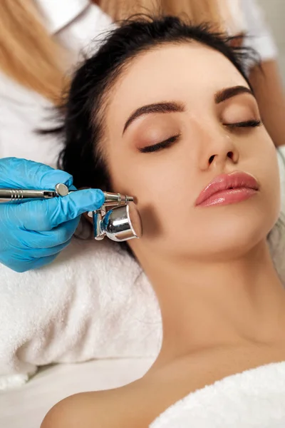 Beautician makes cleaning of face in spa salon. — Stock Photo, Image