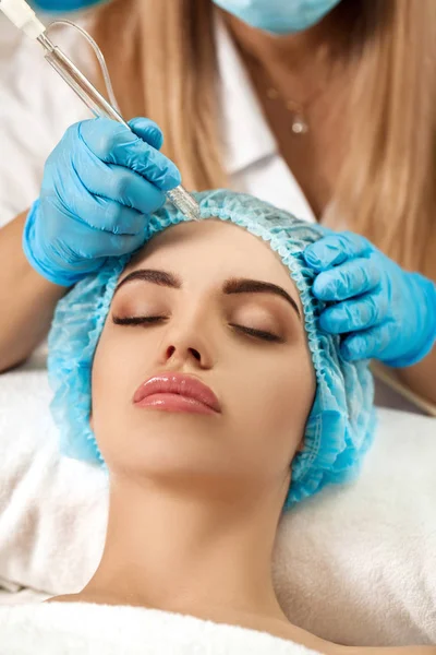 Esteticista hace limpieza de la cara en el salón de spa . — Foto de Stock