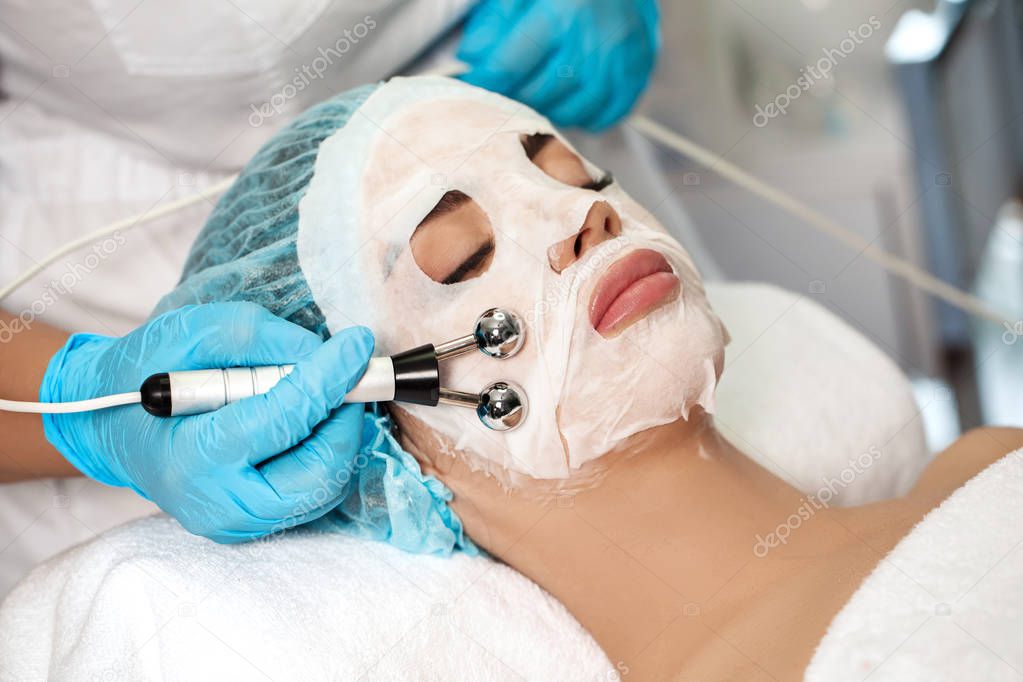 beautician applies face mask on woman