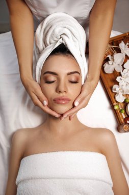 Anti-aging yüz masajı. Spa salonunda masör Masaj aldıktan bir kadın. üstten görünüm