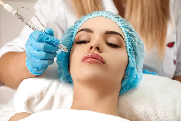 Esteticista hace limpieza de la cara en el salón de spa . — Foto de Stock