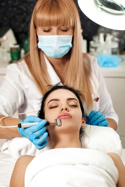 Esteticista hace limpieza de la cara en el salón de spa . — Foto de Stock