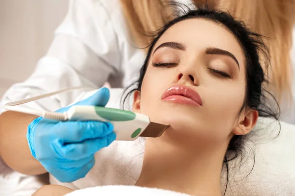 Esteticista hace limpieza de la cara en el salón de spa . — Foto de Stock