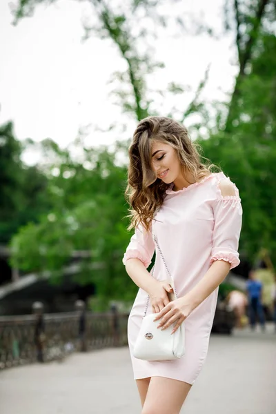 Красивая девушка с сумочкой в парке — стоковое фото
