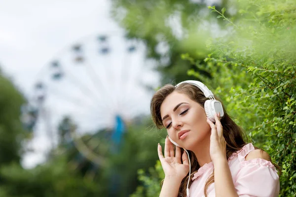 Young woman listening to music on headphones — Stock Photo, Image