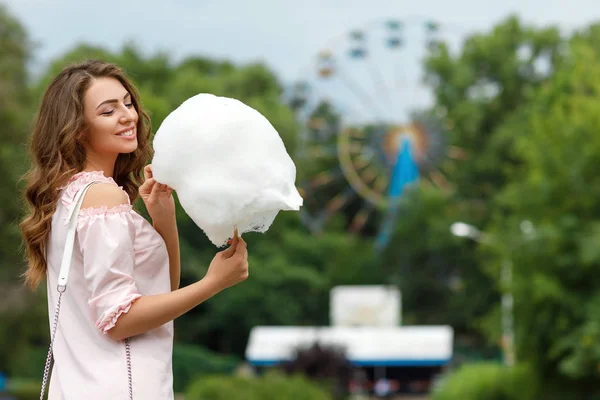 Attractive woman holding sweet cotton candy — Stock Photo, Image