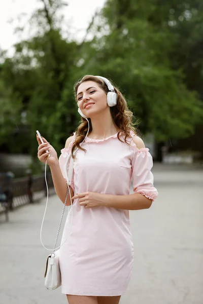 Mujer joven escuchando música en los auriculares — Foto de Stock