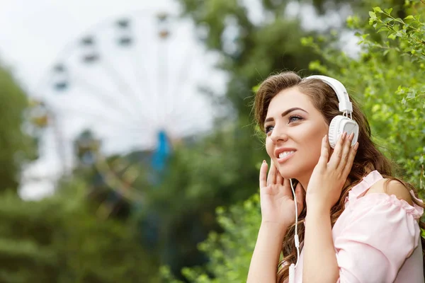 Jovem mulher ouvindo música em fones de ouvido — Fotografia de Stock